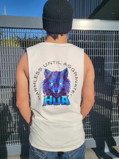 A man wearing a cream sleeveless tank top with a large blue and purple wolf graphic and the word 'HUA' on the back, along with blue jeans and a black beanie, standing on a metal grate outdoors.